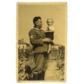 Gebirgsjager de la Wehrmacht alemana posando con un niño en el patio trasero ruso.